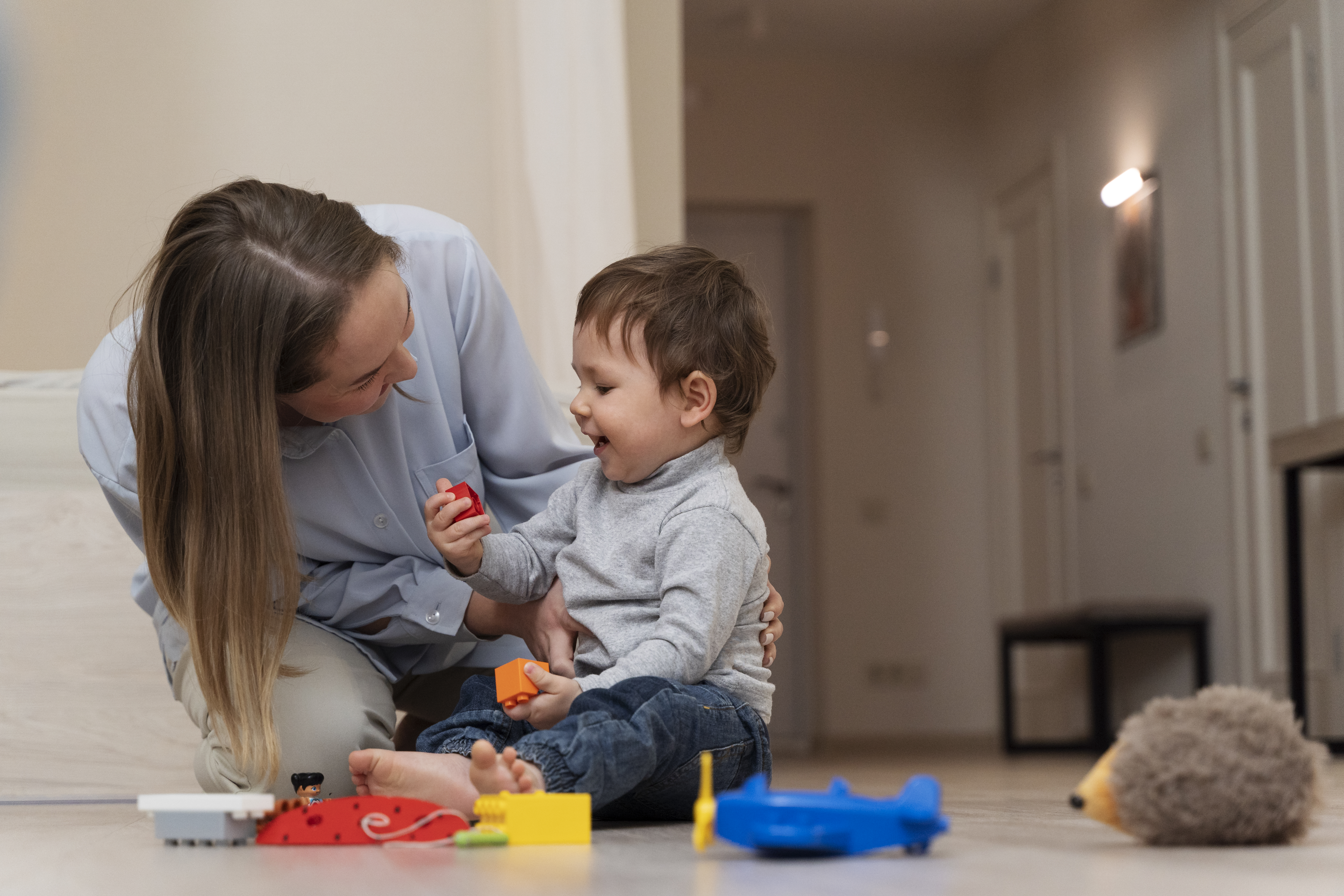 full-shot-smiley-mother-kid-playing-together.jpg